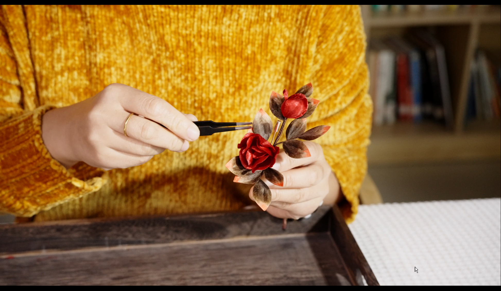Hands crafting velvet flower rose brooch showing traditional Chinese silk floss technique step-by-step