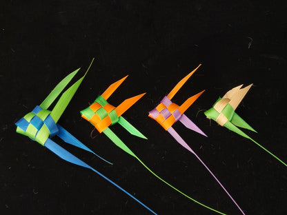 Four colorful Chinese bamboo woven tropical fish in blue, green, orange and pink on black background