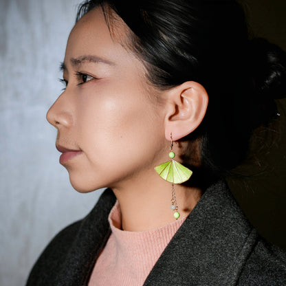 Green fan earrings with golden accents lifestyle photo - sophisticated accessory demonstration