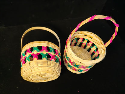 Two identical Chinese bamboo woven baskets with colorful lattice patterns in pink and green on black background