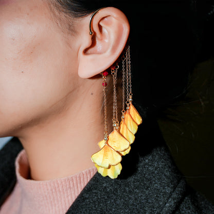 Close-up of yellow ginkgo leaf ear hook worn on ear showing detail and movement