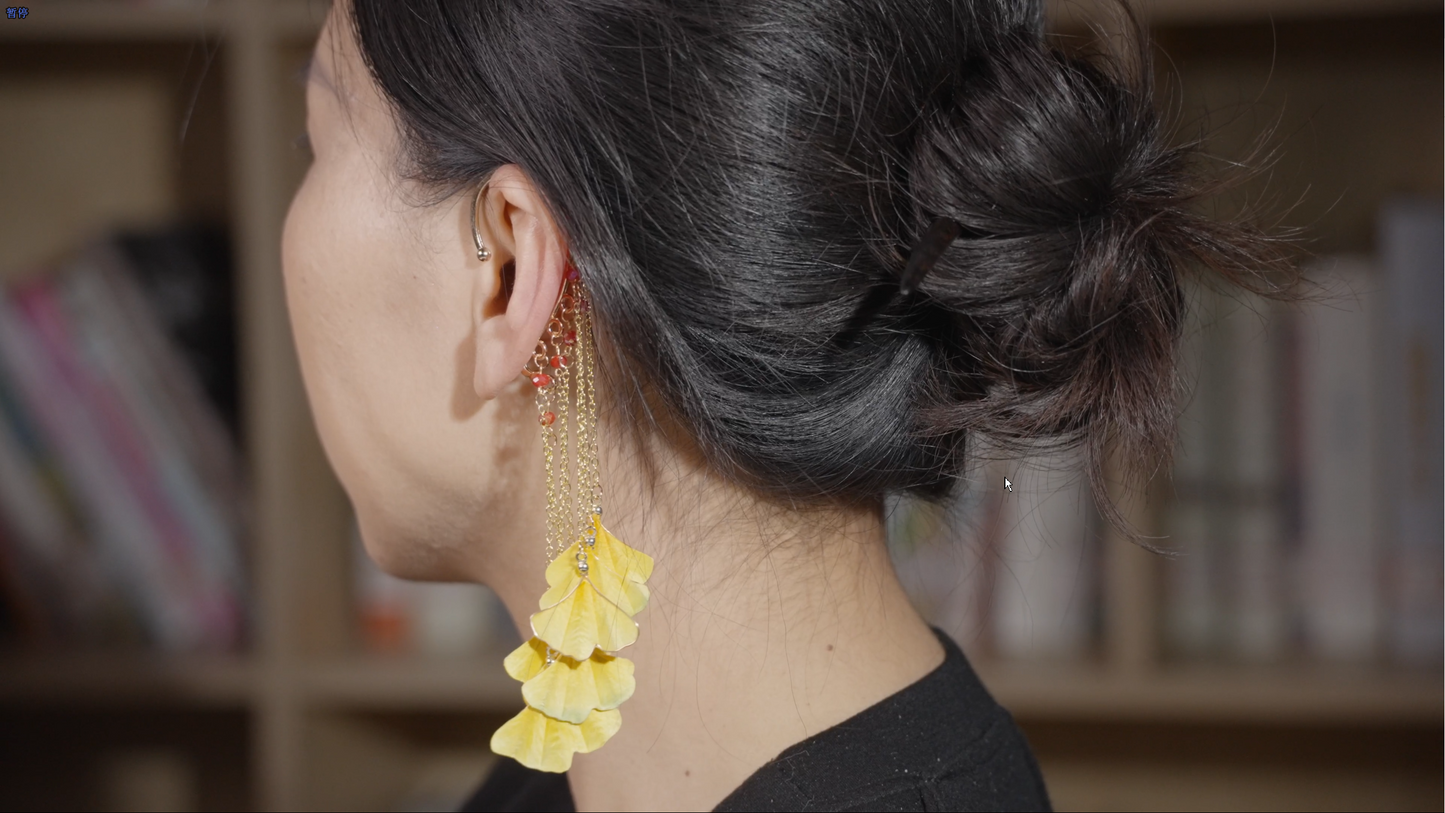 Detailed view of velvet flower ginkgo ear hook with golden tassels - no piercing required