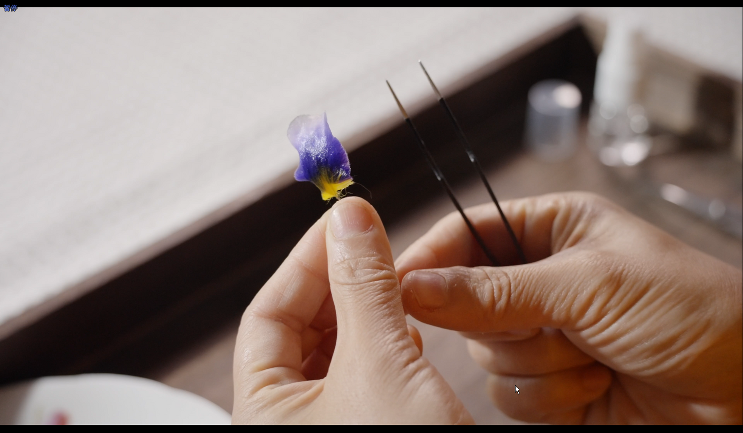 Close-up of iris petal shaping process showing detailed craftsmanship and technique